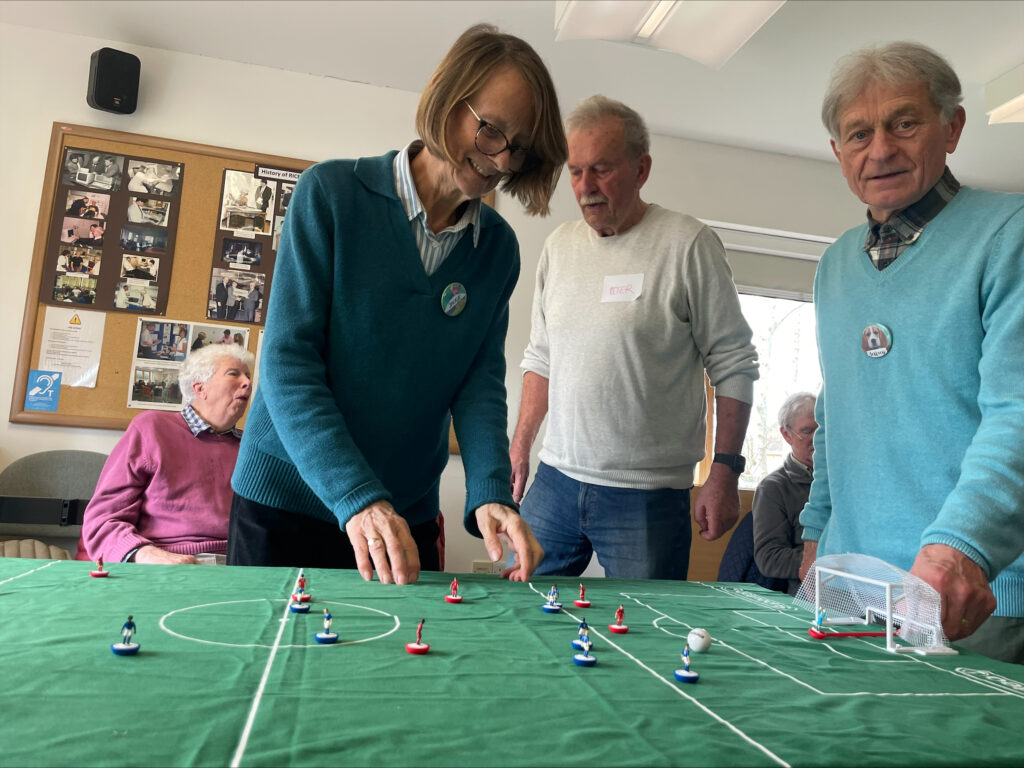 A woman plays table football at a RICE event for people with dementia or memory loss.